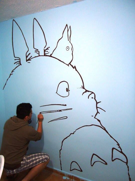 a man is drawing on the wall with black marker