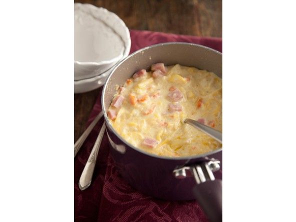 a casserole dish with ham and cheese in it on a red place mat