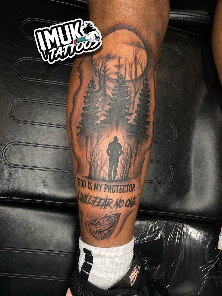 a man with a tattoo on his leg that says, god is my protector killer no one