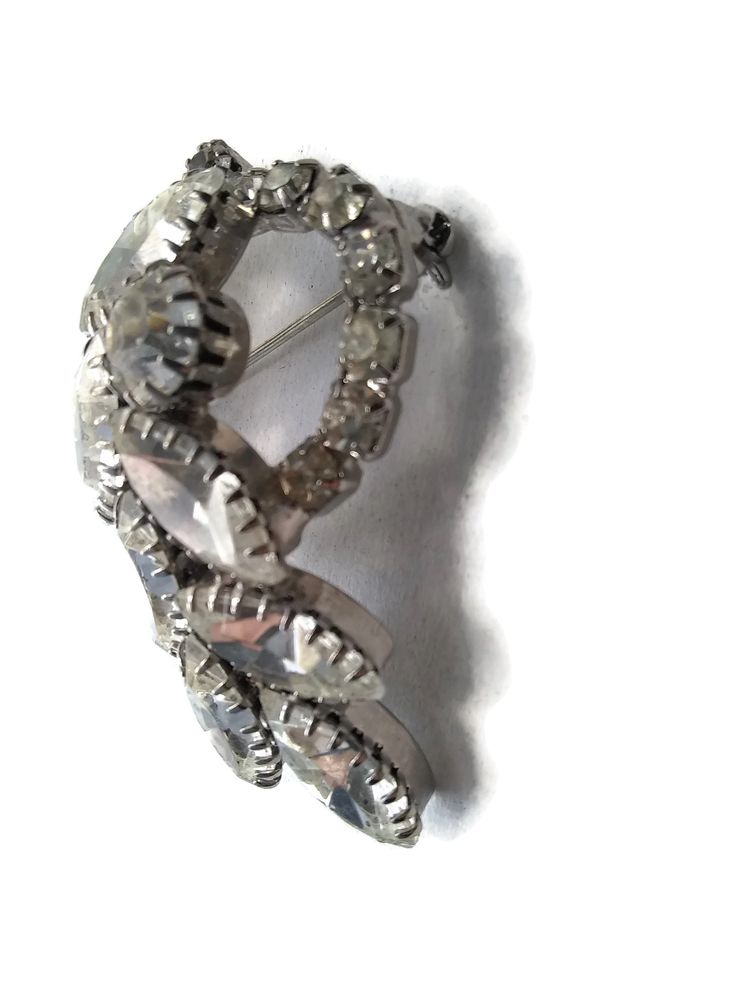 1950s Silver tone Rhodium plated brooch. Clear, prong set gems make this brooch shiny and statement making. The brooch depicts a bleeding heart 3D design. Gift for Her. DETAILS: ☼ Approximately 1 1/2 by 2 inches. ☼ Approximately 14.9 grams, total weight. ☼ ☼ ☼ ☼ ☼ ☼ ☼ ☼ ☼ ☼ ☼ ☼ ☼ ☼ ☼ ☼ ☼ ☼ ☼ ☼ ☼ PLEASE NOTE: ☼ Different items on SALE everyday! Check back often to take advantage of these bargains! ☼ FREE DOMESTIC SHIPPING on purchases of $35 or more. Combined shipping is still available to domest Retro Wedding Brooches With Rhinestones, Vintage Rhinestone Pins For Party, Vintage Rhinestone Party Pins, Vintage Rhinestone Brooches For Anniversary, Silver Rhinestone Brooches For Anniversary, Formal Silver Brooch With Screw Back, Formal Silver Brooches With Screw Back, Silver Costume Jewelry Pins For Formal Occasions, Retro Silver Brooch Pin