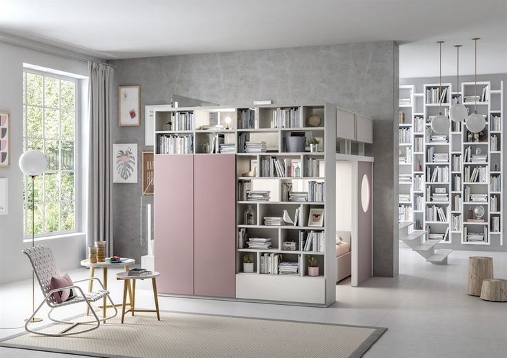 a living room filled with furniture and a book shelf next to a large open window