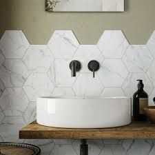 a bathroom with marble hexagonal tiles on the wall and wooden countertop, along with a round sink