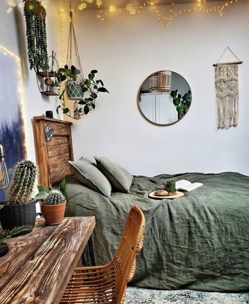 a bedroom with a bed, table and hanging plants