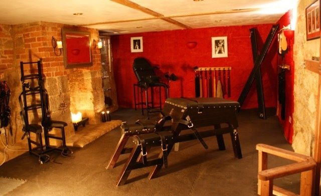 a room filled with lots of furniture and red brick walls, along with pictures on the wall