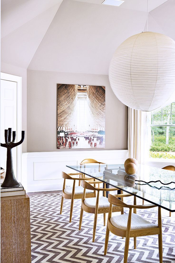 a dining room table with chairs and a large lantern hanging from the ceiling above it