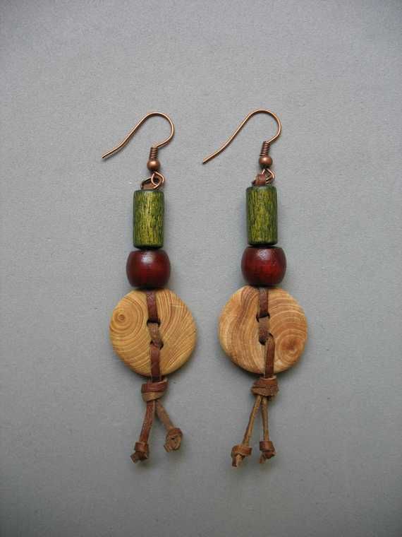 two wooden earrings with green and red beads hanging from it's earwires