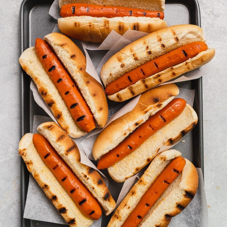 hotdogs and buns on a tray ready to be cooked in the oven