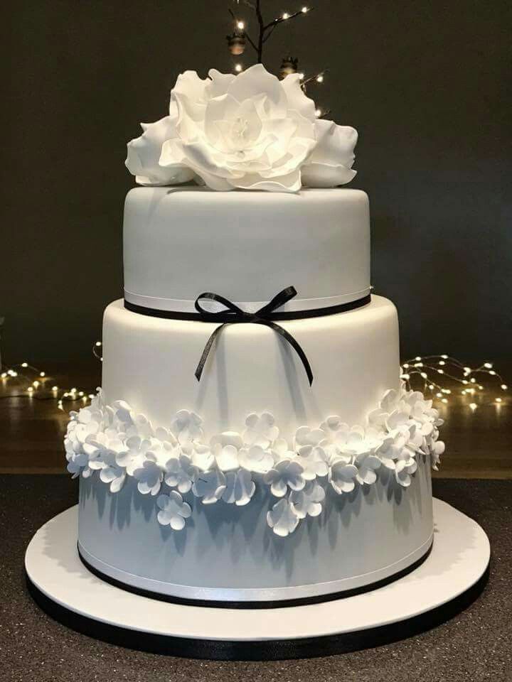 a three tiered cake with white flowers on top