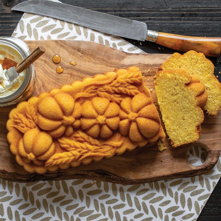 a wooden cutting board topped with cake next to a knife