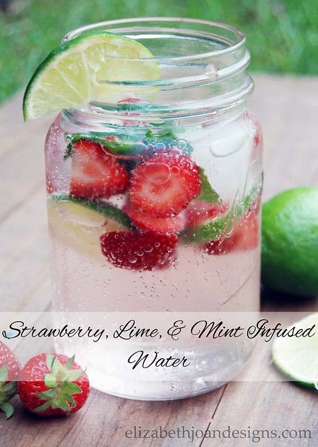 strawberry lime and mint infused water in a mason jar with strawberries on the side