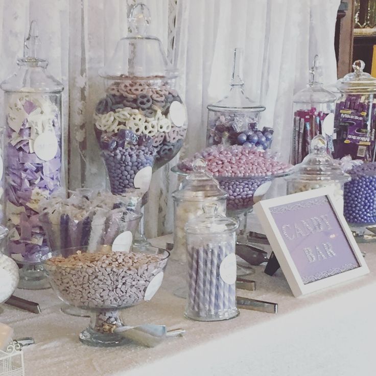 an assortment of candy and candies on display in front of a white table cloth