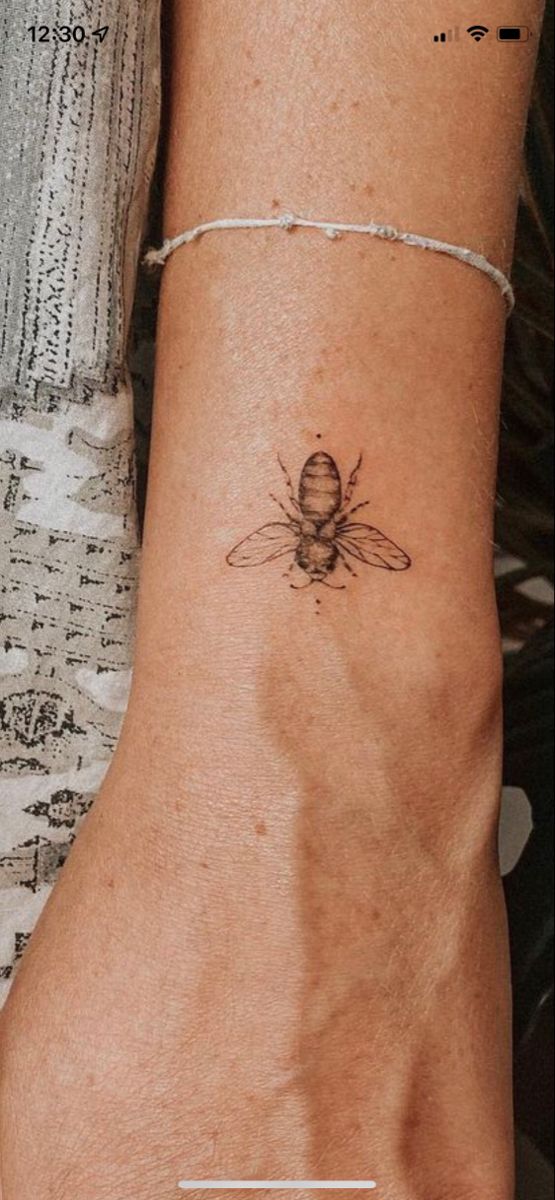 a woman's foot with a bee tattoo on the left side of her ankle