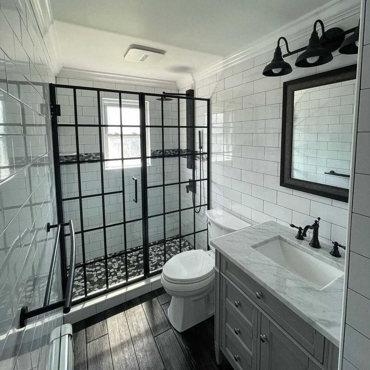 a bathroom with white tile and black accents