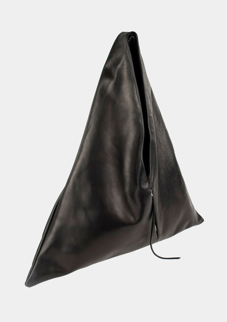 Angular sculpted black leather tote bag with an exterior zip pocket. Lined in a durable cotton canvas with inside leather cell phone pocket. Worn comfortably on the shoulder and hand held.Materials:100% Italian Cowhide Leather100% Cotton Canvas LiningSilver Zippers Dimensions:Handle drop - 14″Width - 24.5″Height - 26.5″Bottom Depth - 3″ Closet Manifestation, Triangle Tote, Luxury Gloves, Positive Aura, Leather Work Bag, Triangle Bag, Black Leather Tote Bag, Black Leather Tote, Work Bag