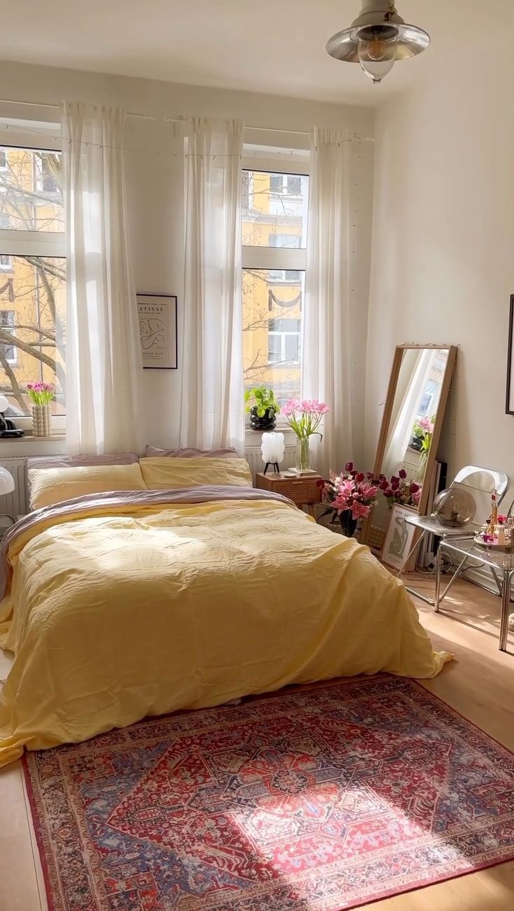 a bed sitting in a bedroom next to two windows