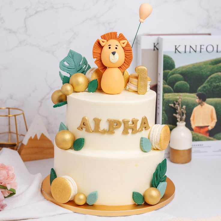 a white and gold cake with a lion topper sitting on it's side