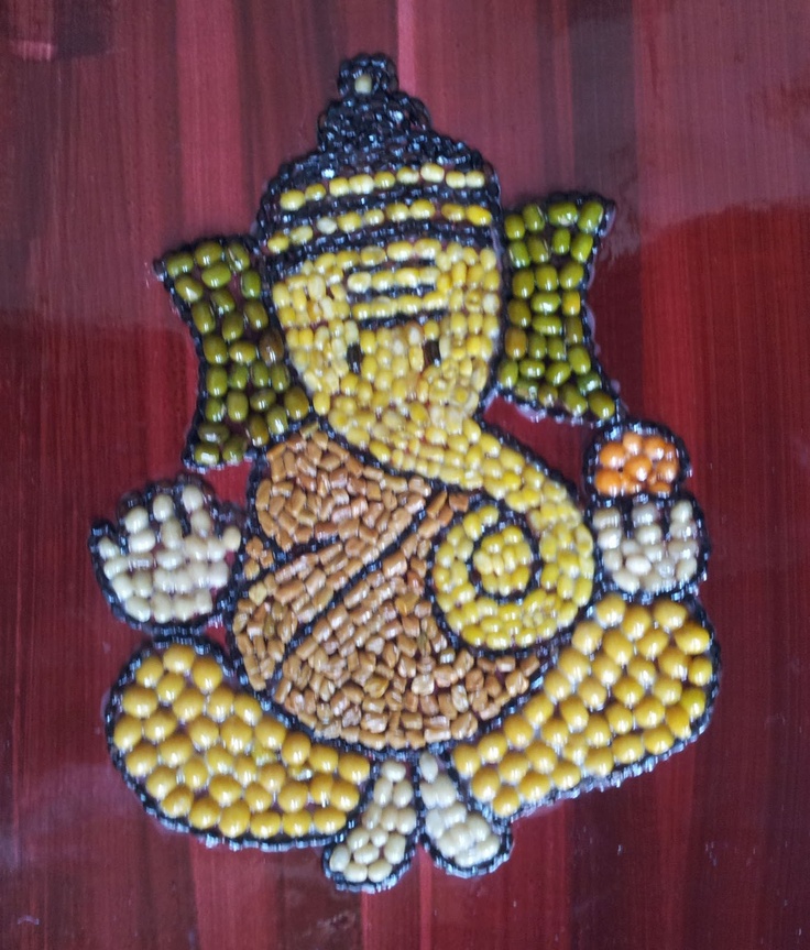 a small beaded buddha sitting on top of a wooden table next to a red wall