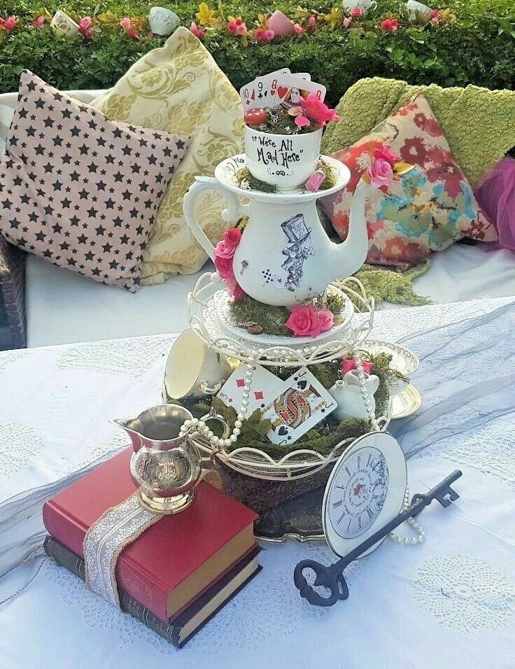 there is a tea pot on top of a table with books and other items around it