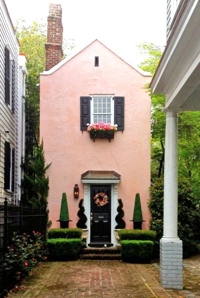 a pink house with black shutters and white trim