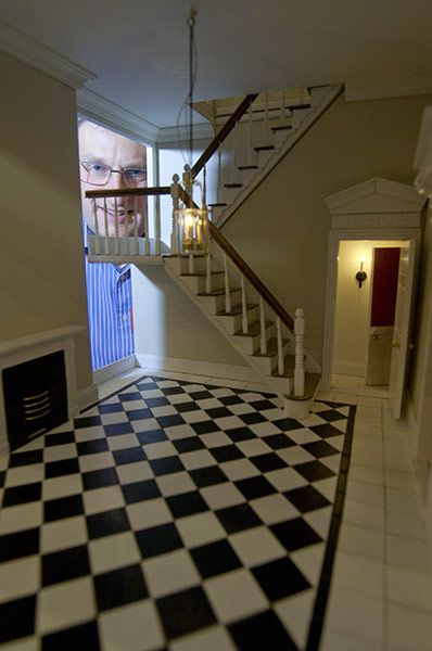 a black and white checkered floor with a staircase leading to the upper level area