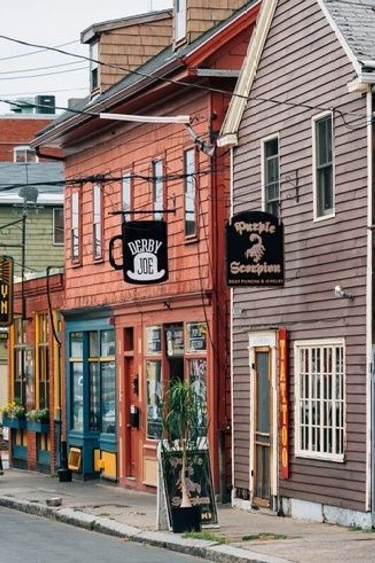 an image of a small town street with shops on both sides and people walking down the sidewalk