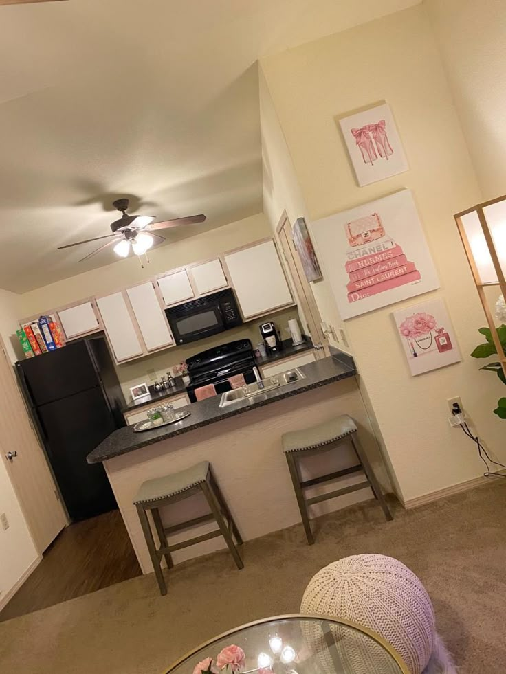 a kitchen and living room area in an apartment with white walls, carpeting and furniture