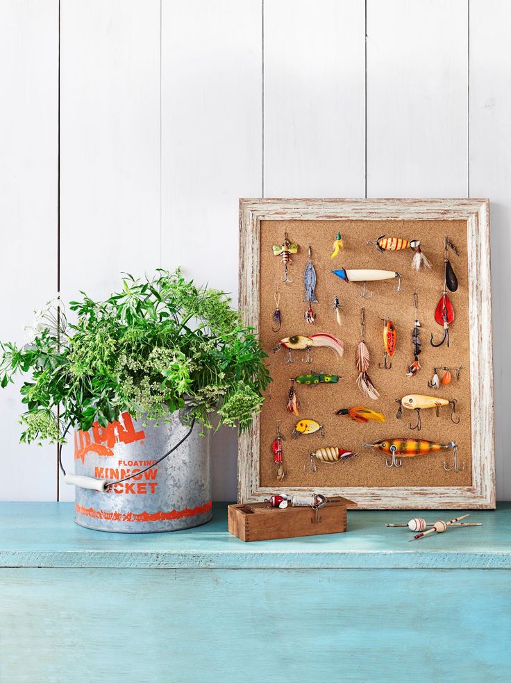 a wooden frame with fishing lures on it and a potted plant next to it