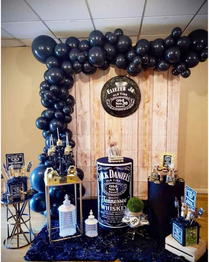 a table topped with black balloons and other items