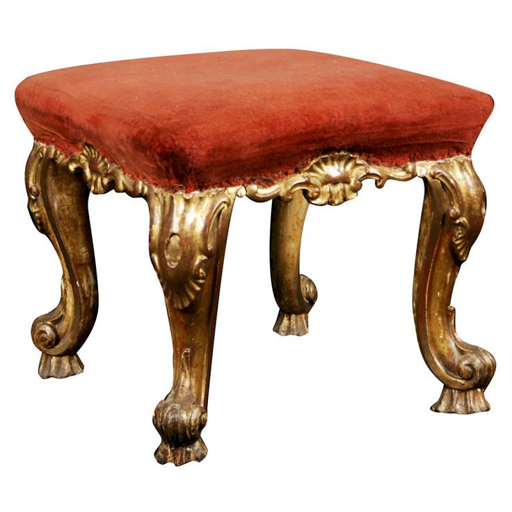 a gold bench with a red cushion on it