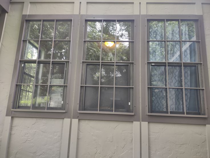 two windows with bars on each side and one window has a street light in the middle