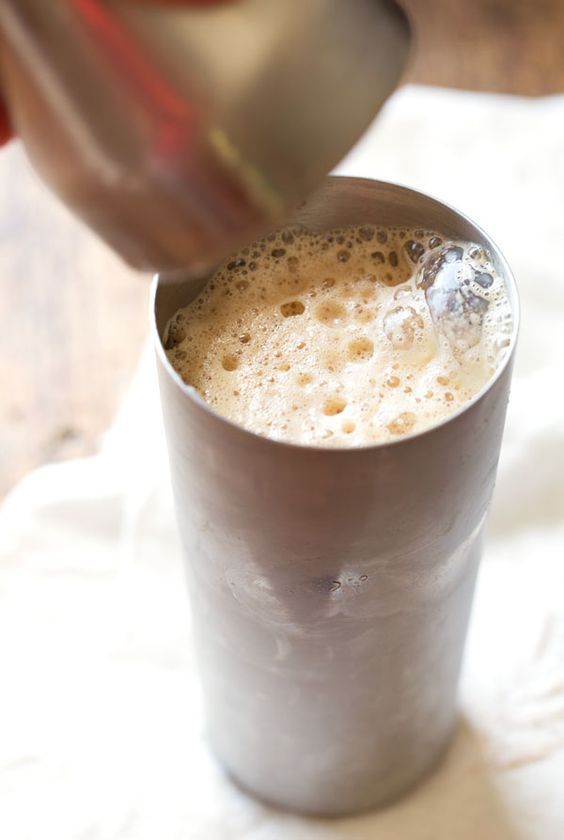 a person is pouring something into a cup