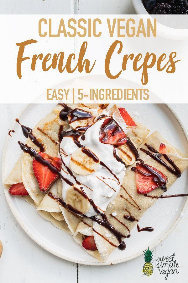 a white plate topped with crepes covered in whipped cream and strawberries