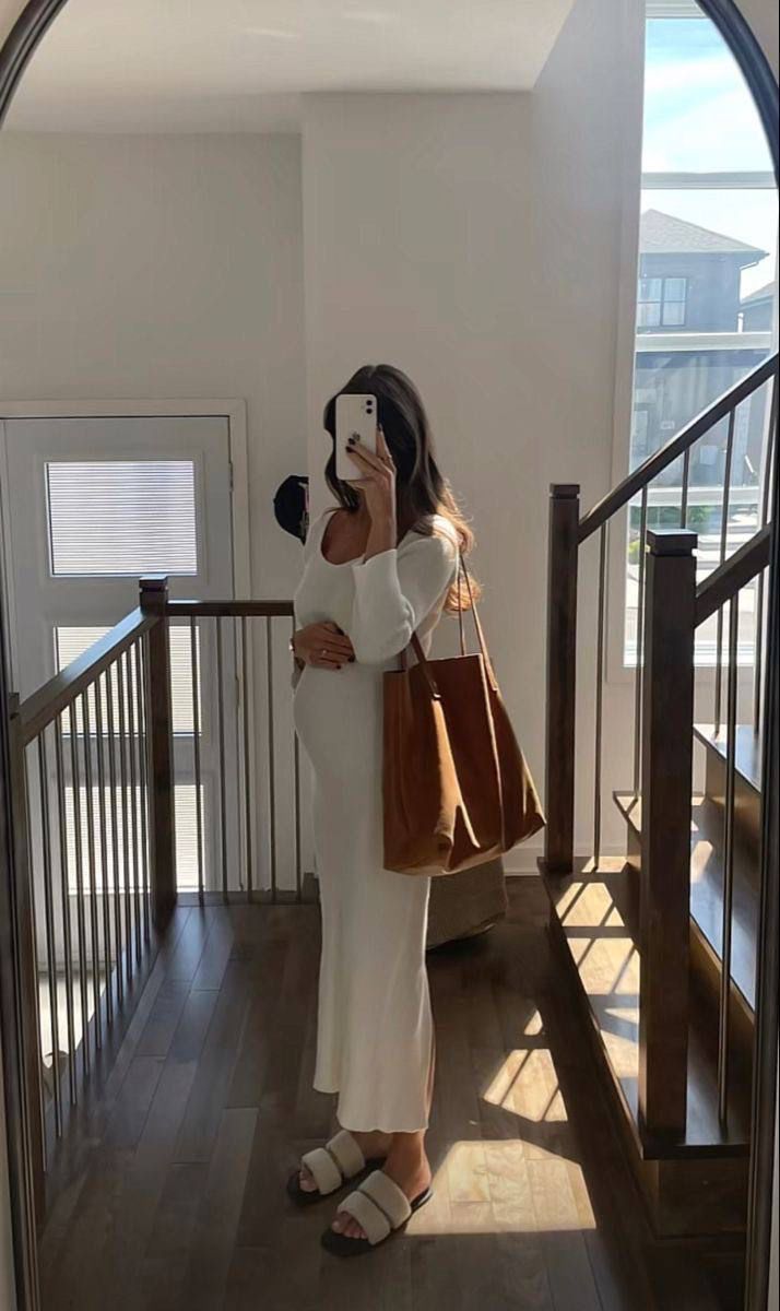 a woman taking a selfie with her cell phone while standing in front of stairs