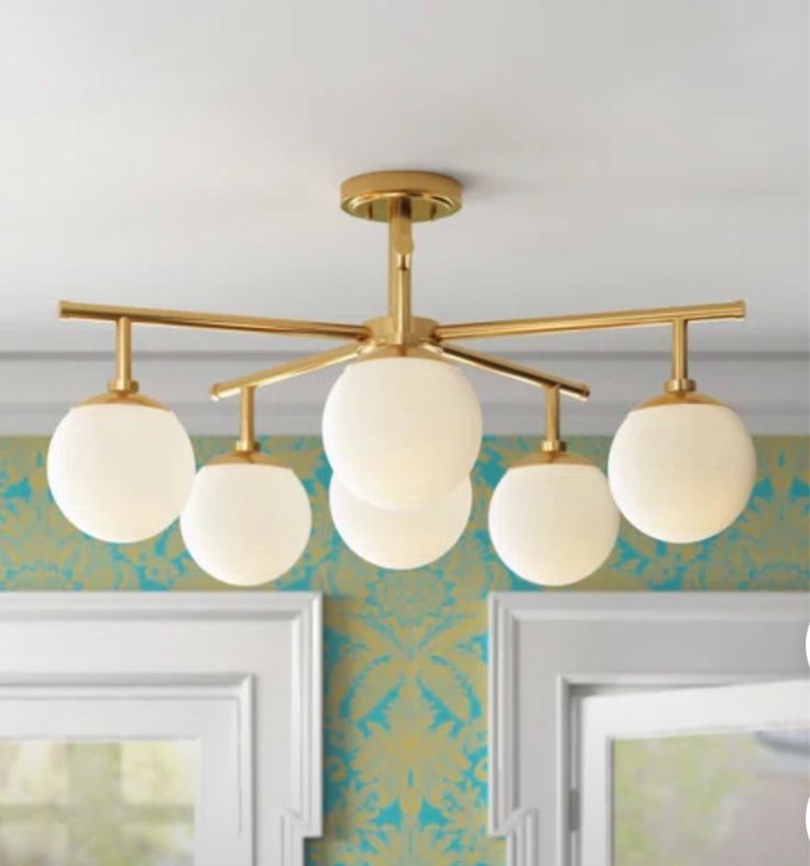 an overhead light fixture in a room with green wallpaper and white trim on the walls