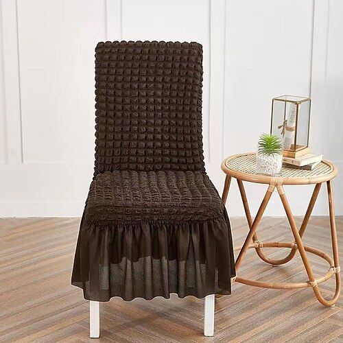 a brown chair sitting on top of a hard wood floor next to a small table