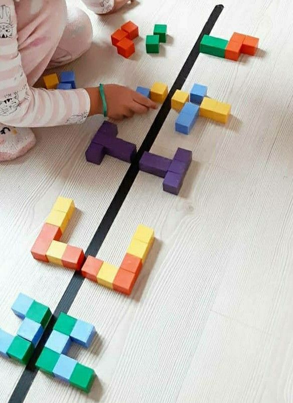 a child playing with wooden blocks on the floor