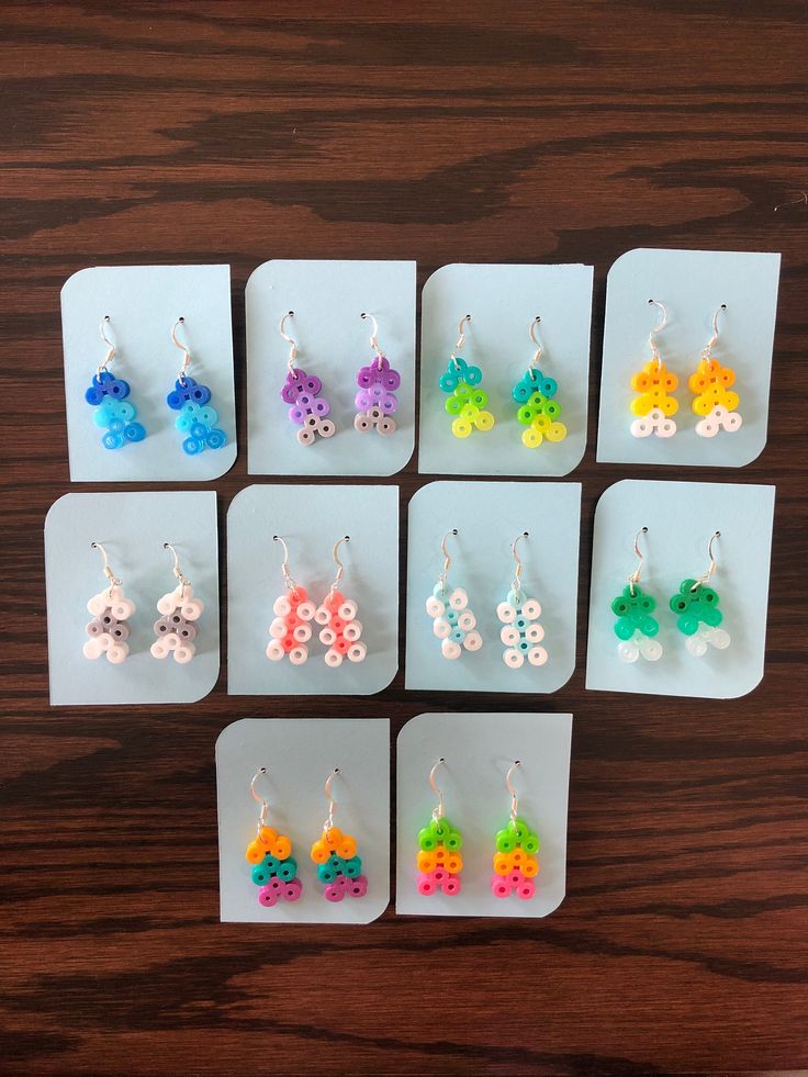 six pairs of earrings made out of legos and plastic beads, all in different colors