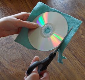 someone cutting up a cd with scissors on a table