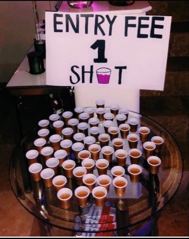 a table topped with lots of cups and a sign that says entry fee 1 shot