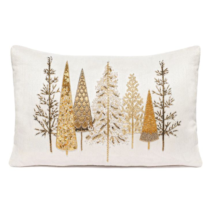 a white pillow with gold christmas trees on the front and bottom, along with an embroidered border