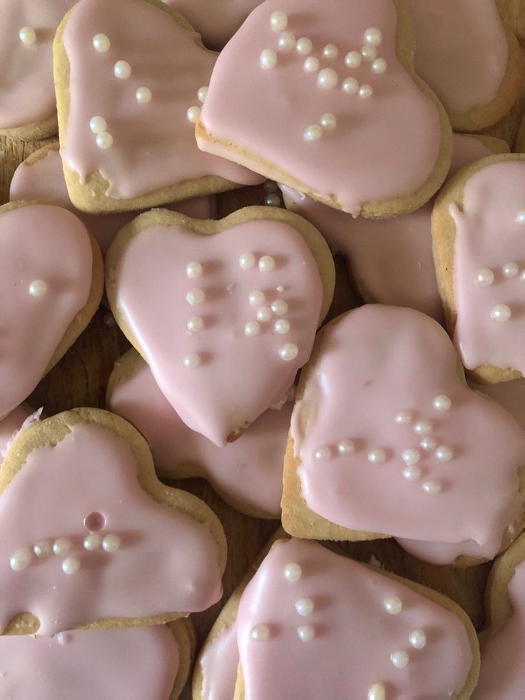 some pink heart shaped cookies with white frosting