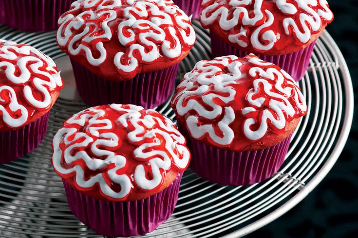 red cupcakes with white frosting on a wire rack