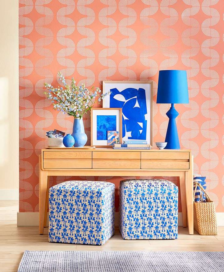 an orange wall with blue and white decor on it, along with two stools