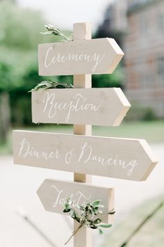 a wooden sign that says ceremony reception, dinner and dancing with greenery on it