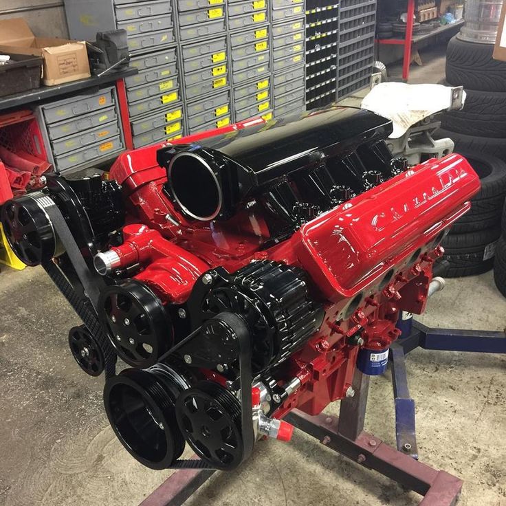 a red engine sitting on top of a metal stand