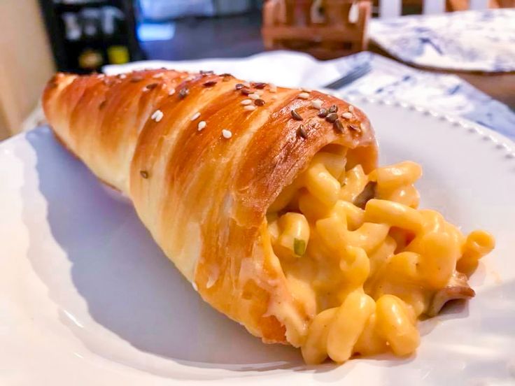 a piece of bread with macaroni and cheese in it on a white plate