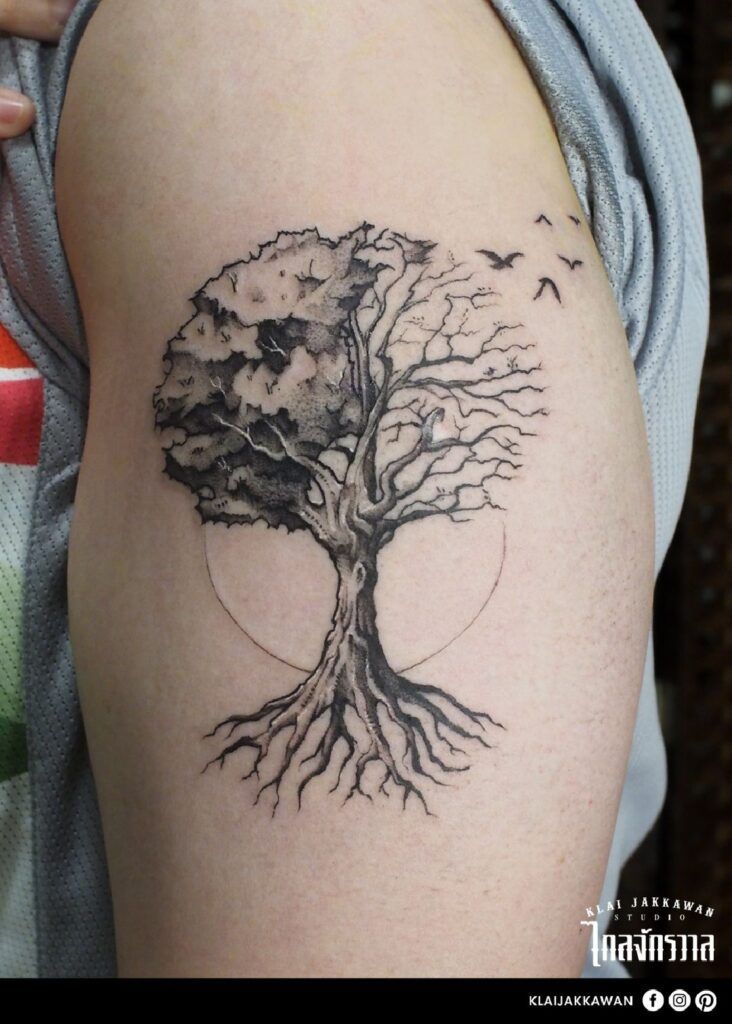 a tree tattoo on the arm with birds flying around it