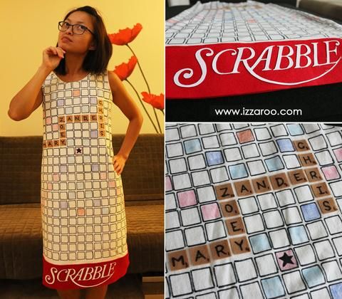 a woman standing in front of a scrabble sign and the word scrabble spelled on it