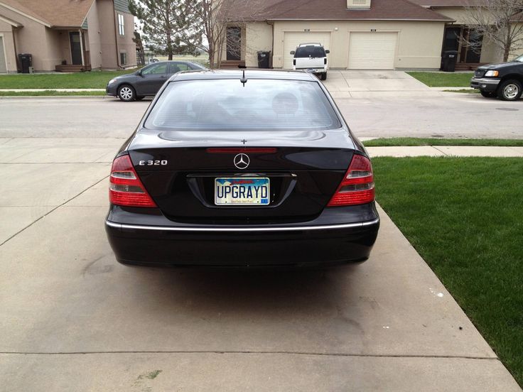 the back end of a black mercedes benz s - class parked in front of a house