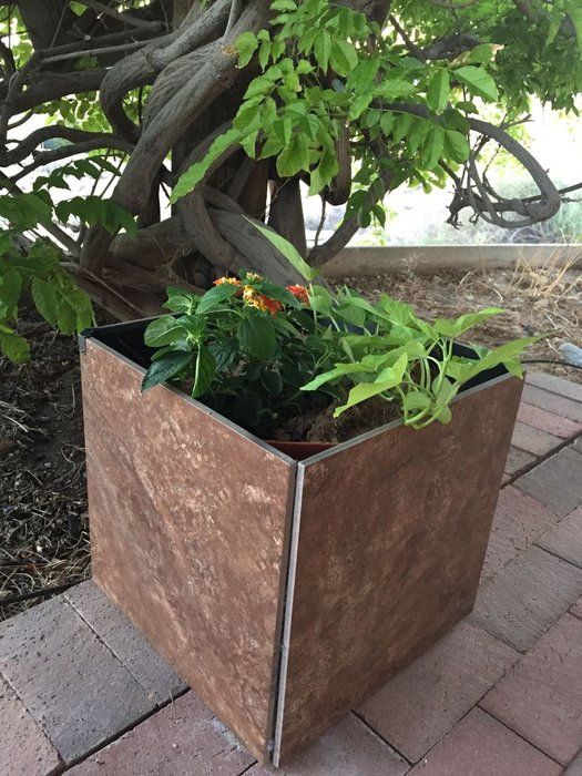 a metal planter with plants in it